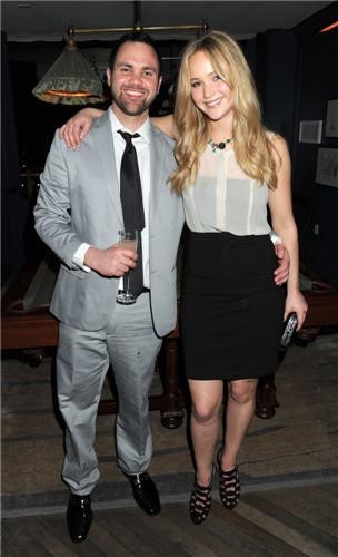 Blonde Jennifer Lawrence in a short black miniskirt and white top
