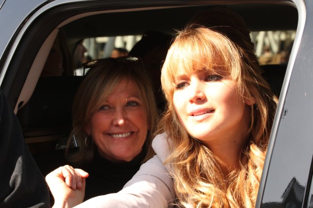 Jennifer Lawrence in her car greeting fans on her way to The Hunger Games The Hob Event.
